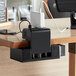 A Luxor EdgePower clamp-on charging unit attached to a table with a laptop charging on it.