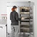 A woman opening a Beverage-Air Horizon Series refrigerator in a professional kitchen.