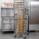 A stainless steel bun and sheet pan rack with multiple trays holding baked goods, designed for commercial kitchen use.