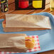 Carnival King plain Kraft paper hot dog bags on a tray with hot dogs.