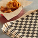 A stack of Choice Kraft black check deli sandwich wrap paper.