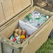 A CaterGator divider for a cooler with food and drinks in it on a table outdoors.