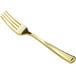 A close up of a Visions gold plastic fork with a white background.