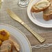 A plate with a piece of bread and a Visions heavy weight gold plastic knife on it.