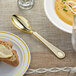 A Visions gold plastic spoon on a plate.