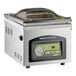 A stainless steel tabletop vacuum packaging machine with a digital control panel and a clear domed lid.