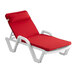A red chaise cushion with a pillow on a white chaise lounge.