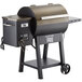 A black and brown Backyard Pro wood-fired pellet grill with wheels.