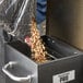 A person pouring wood pellets into a black box.