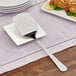 A GET stainless steel spatula with a mirror finish on a plate.
