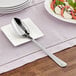 A stainless steel serving spoon on a plate.