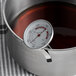 A Taylor 5911N Candy / Deep Fry Probe Thermometer in a pot of liquid.
