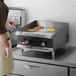 A man cooking pancakes on a Cooking Performance Group countertop griddle.