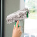 A hand holding a green Unger ErgoTec Ninja window cleaning sleeve.