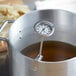 A Comark candy / deep fry thermometer in a pot of boiling liquid.