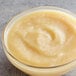 A bowl of Les Vergers Boiron pear puree on a marble table.