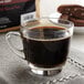 A glass cup of Crown Beverages Royal Reserve Guatemalan coffee on a table.