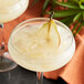 A glass of Les Vergers Boiron pear puree with ice and a pear slice.