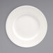 A white plate with a wide white rim on a gray background.
