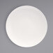 A Front of the House European white porcelain plate with a white rim on a gray surface.