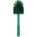 A close-up of a green Carlisle Sparta multi-purpose cleaning brush with bristles.