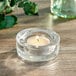 A Sterno tea light candle in a clear glass holder.