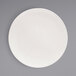 A Front of the House European white porcelain plate with a spiral pattern on the rim.
