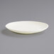 A Front of the House European White porcelain plate with a small rim on a gray surface.