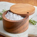 A Fox Run acacia wood salt cellar with white crystals inside.