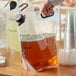 A close-up of a hand holding a Choice plastic bag filled with brown liquid.