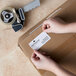 A person's hands holding a Lavex blank paper label.