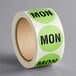 A roll of green Lavex paper labels with the word "Mon" in black.