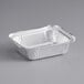 A silver oblong foil container with a square lid.