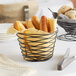 An American Metalcraft black birdnest basket filled with bread and utensils on a table.