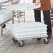 A woman holding a tray of white Regency dough proofing boxes.