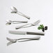 An Arcoroc stainless steel dinner spoon on a white surface.