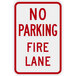 A white rectangular sign with red text that reads "No Parking / Fire Lane" and a red border.