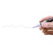 A hand holding a Deflecto white chisel tip marker with a white cap.