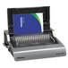 A close-up of a Fellowes Galaxy electric comb binding machine with a blue and green cover.
