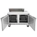 A stainless steel Beverage-Air refrigerator with two doors and a food prep table inside.