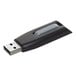 A close-up of a black and grey Verbatim Store 'n' Go V3 USB flash drive. The black and grey USB drive has a logo.