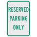A white and green sign that says "Reserved Parking Only" in green text.