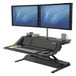 A Fellowes Lotus DX sit-stand workstation with two computer monitors on it.