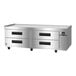 A stainless steel refrigerated chef base with four drawers and caster wheels.