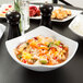 An American Metalcraft square stoneware bowl filled with rice and vegetables.