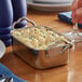 A rectangular stainless steel roasting pan with macaroni and cheese in it.