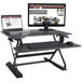 A Victor sit-stand workstation with a laptop and keyboard on a desk.