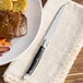 A plate of food with a Lou Laguiole steak knife on it.