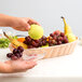 a hand holding a plate of fruit