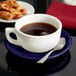 A Tuxton cobalt saucer with a cup of coffee and a plate of pastries.